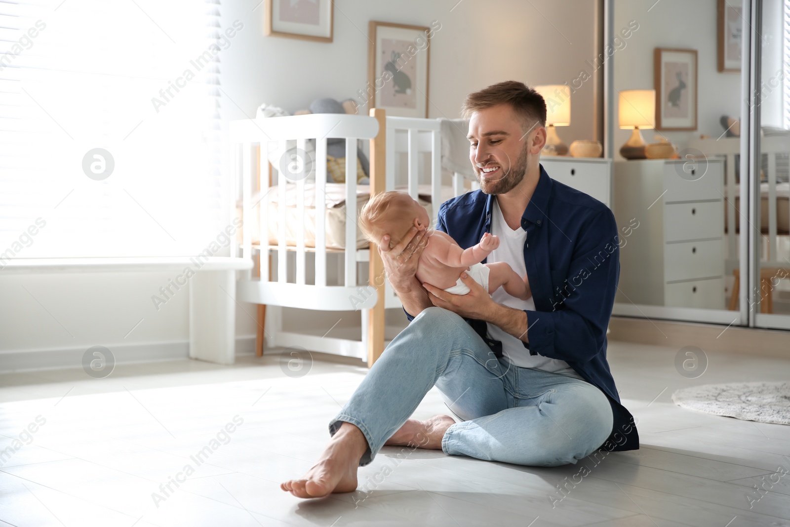 Photo of Father with his newborn son at home