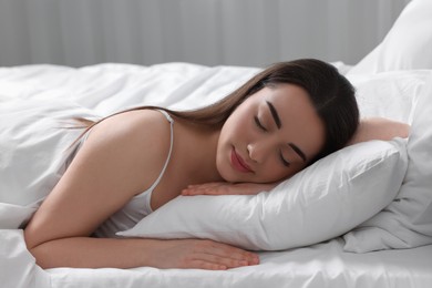 Beautiful young woman sleeping in soft bed at home