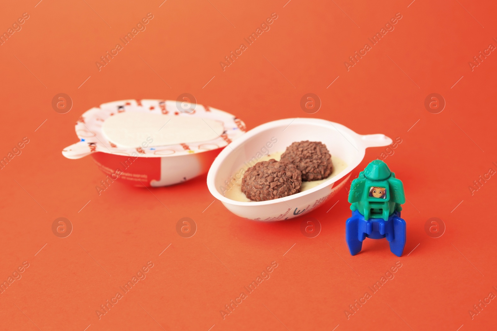 Photo of Slynchev Bryag, Bulgaria - May 25, 2023: Halves of Kinder Joy Egg with sweet candies and toy on orange background