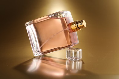 Luxury women's perfume. Sunlit glass bottle on golden background