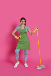 Photo of Young woman with yellow broom on pink background