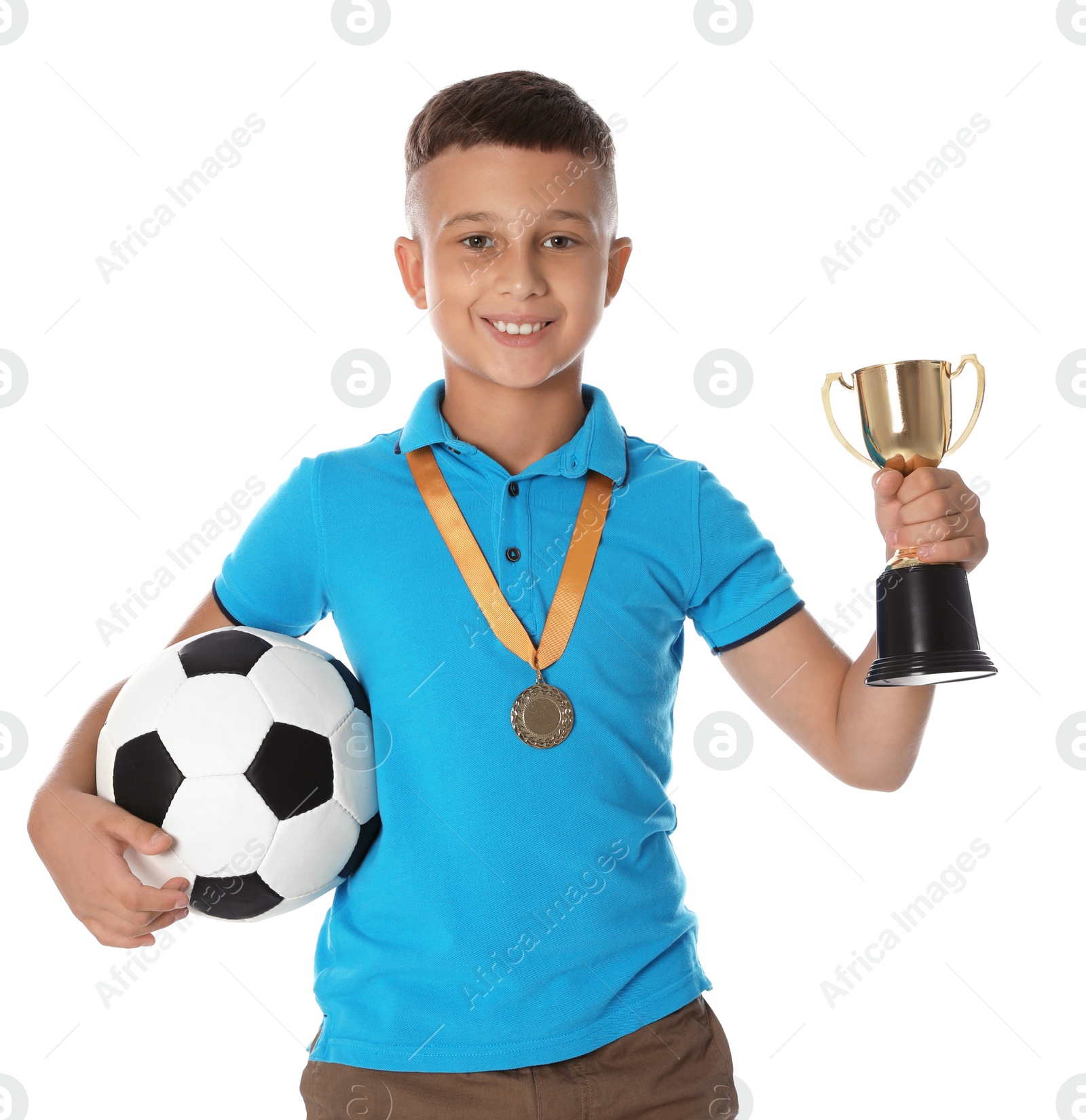 Photo of Happy boy with golden winning cup, medal and soccer ball on white background