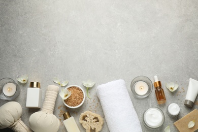 Flat lay spa composition with skin care products on grey table, space for text