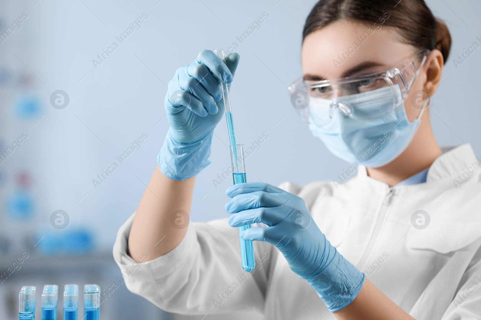 Photo of Scientist taking sample with dropper from test tube in laboratory