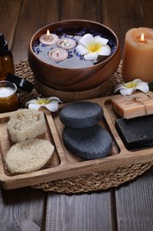 Photo of Beautiful composition with different spa products, plumeria flowers and burning candles on wooden table