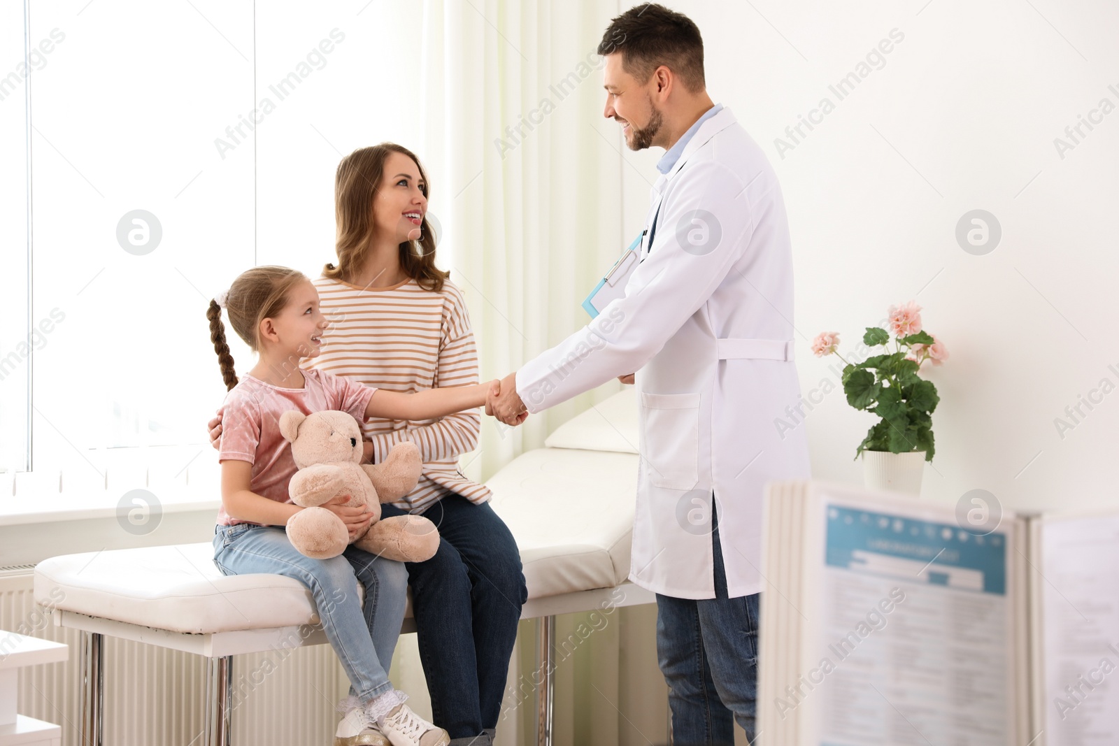 Photo of Mother and daughter visiting pediatrician. Doctor working with patient in hospital