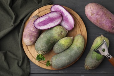 Photo of Green and purple daikon radishes on gray wooden table, flat lay