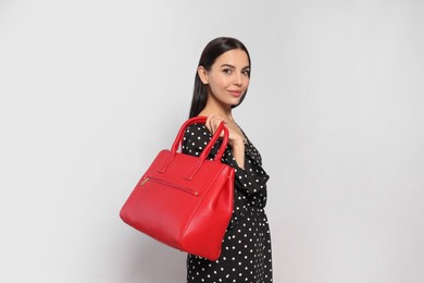 Young woman with stylish bag on white background,