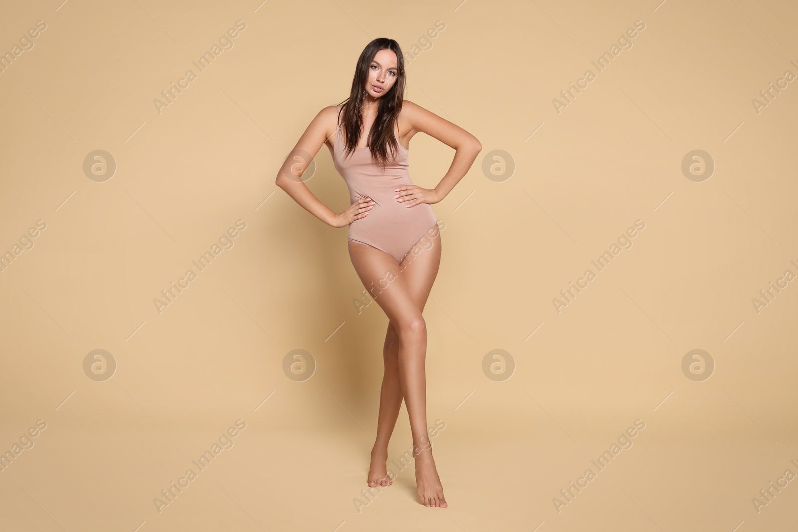 Photo of Beautiful woman wearing bodysuit on beige background