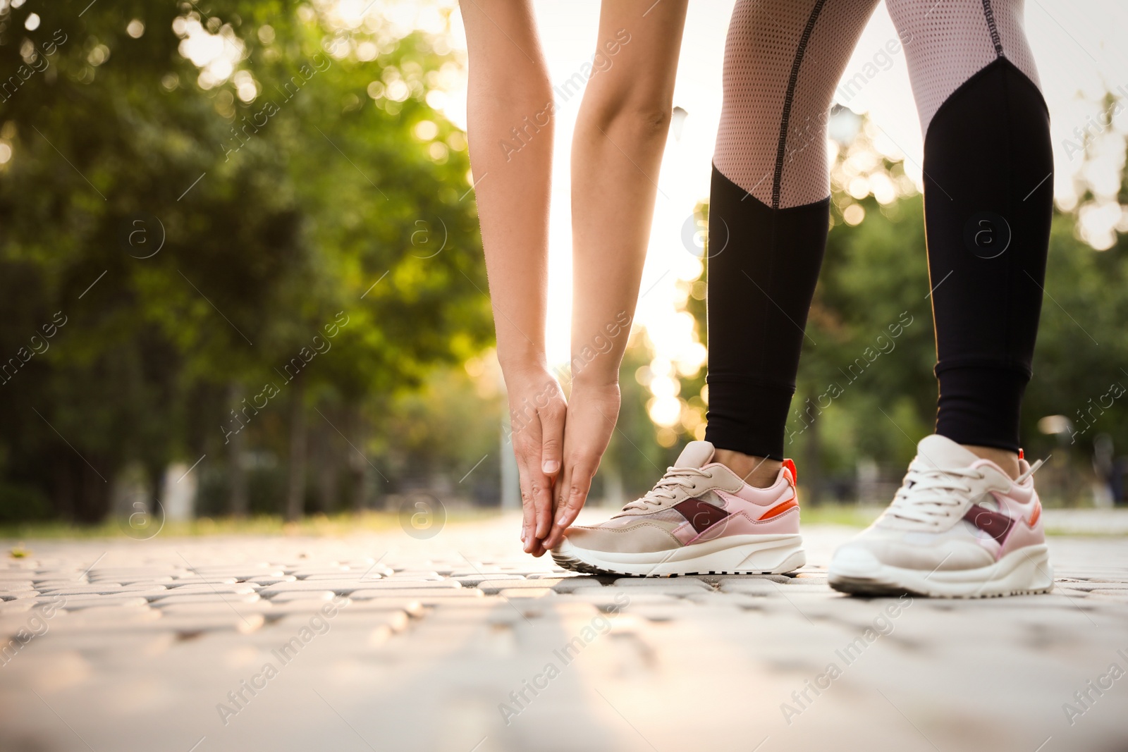 Photo of Woman stretching before morning run in park, closeup. Space for text