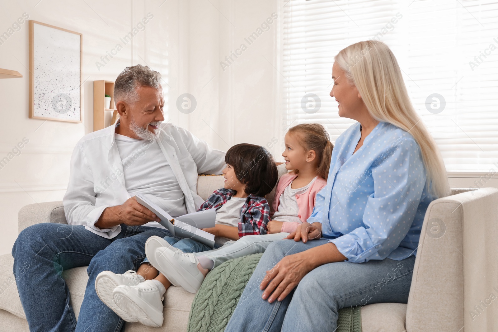 Photo of Happy grandparents spending time with grandchildren at home