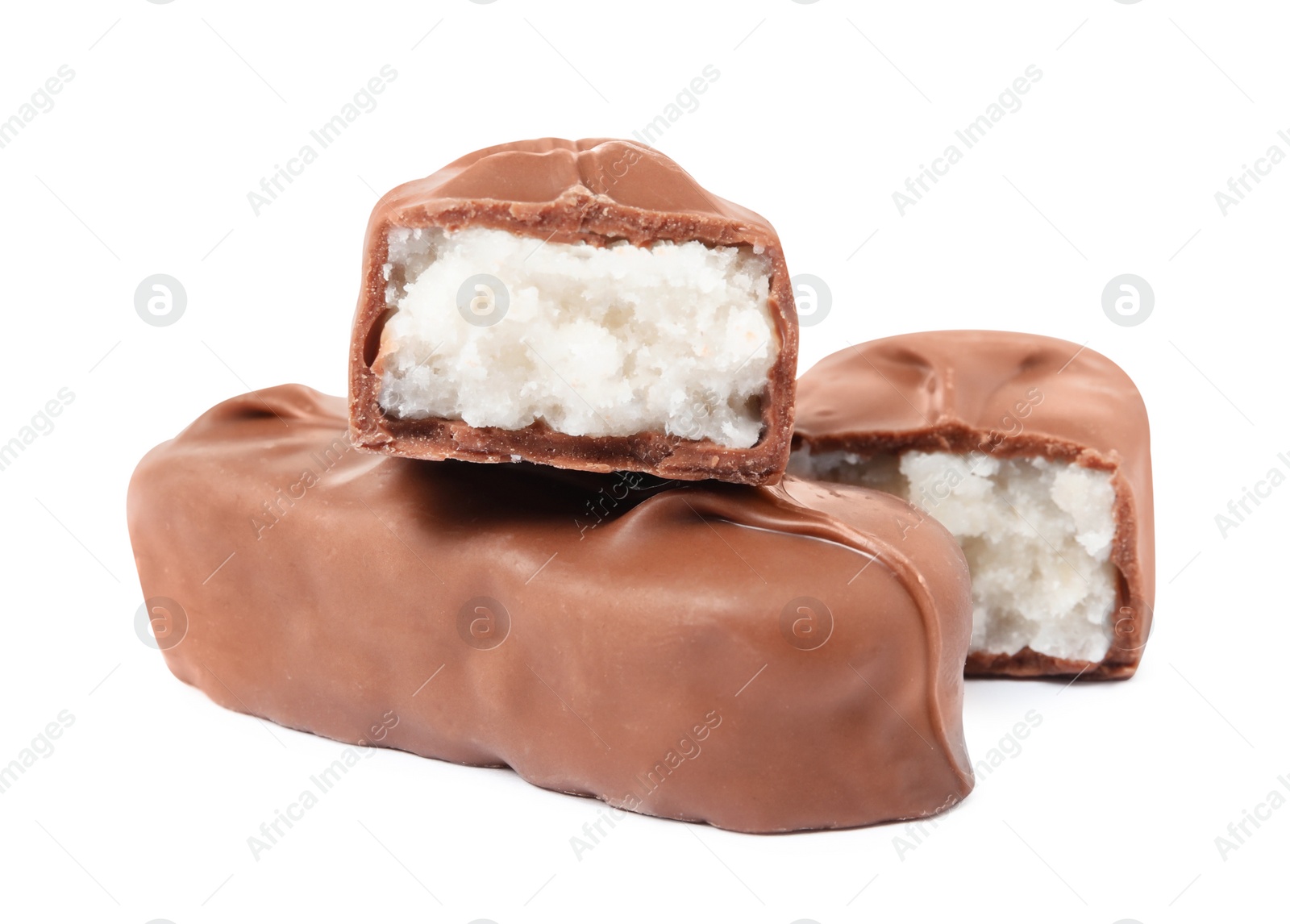 Photo of Delicious milk chocolate candy bars with coconut filling on white background