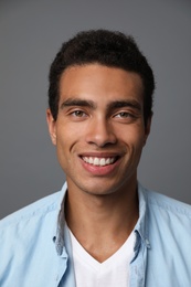 Photo of Handsome young African-American man on grey background