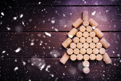 Image of Christmas tree made of wine corks on wooden table, top view. Space for text