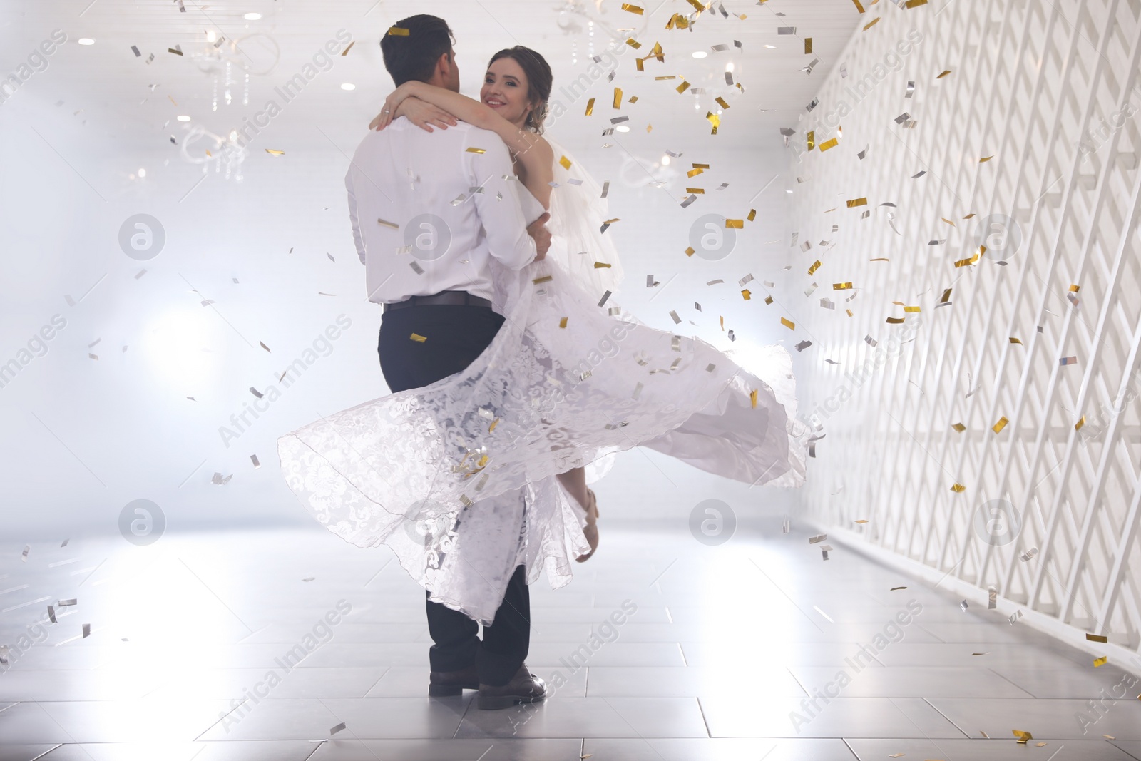 Photo of Happy newlywed couple dancing together in festive hall