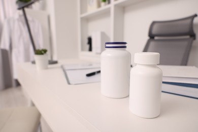 Photo of Plastic medical bottles on white table, space for text. Doctor's workplace