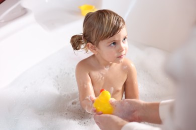 Mother playing with her little daughter in bath tub, closeup