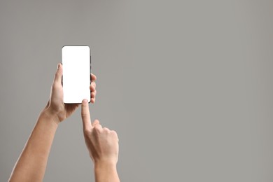 Photo of Man using smartphone with blank screen on light grey background, closeup. Mockup for design