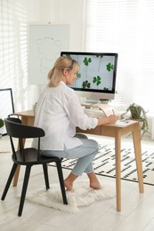 Photo of Happy woman working at table in light room. Home office