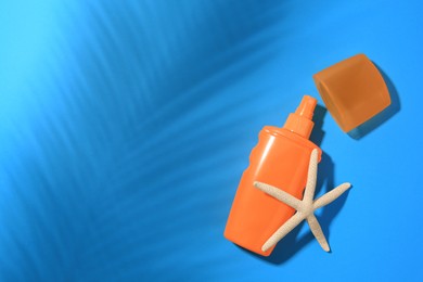 Photo of Sunscreen and starfish on light blue background, top view and space for text. Sun protection care