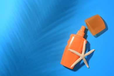 Sunscreen and starfish on light blue background, top view and space for text. Sun protection care