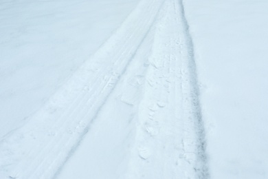 Car tire tracks on fresh snow, outdoors