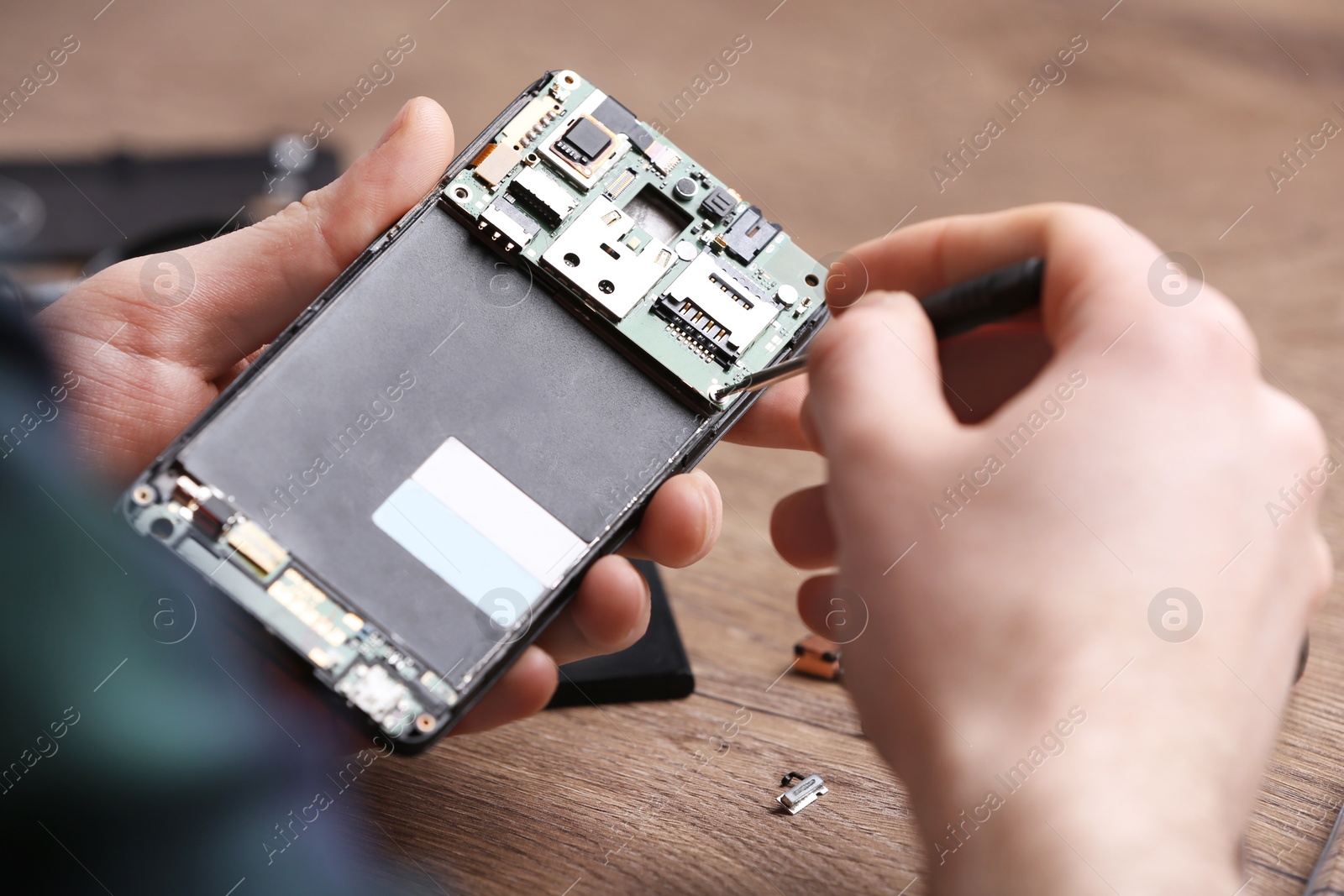 Photo of Technician fixing mobile phone at table, closeup. Device repair service