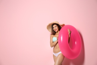 Photo of Beautiful young woman with inflatable ring on color background