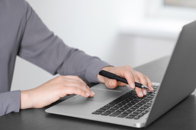 Woman working on laptop at table, closeup. Electronic document management