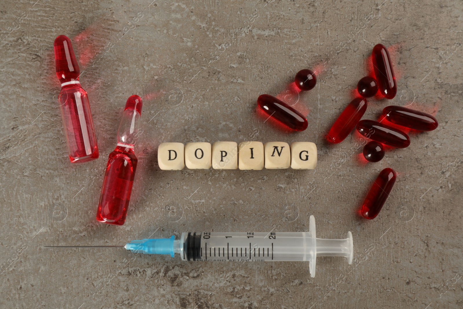 Photo of Wooden cubes with word Doping and drugs on grey background, flat lay