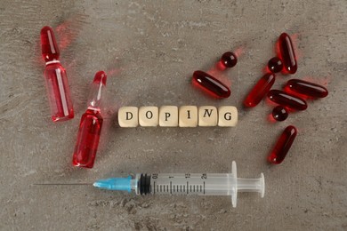 Wooden cubes with word Doping and drugs on grey background, flat lay