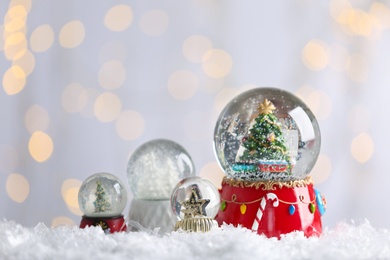 Photo of Beautiful snow globes against blurred Christmas lights