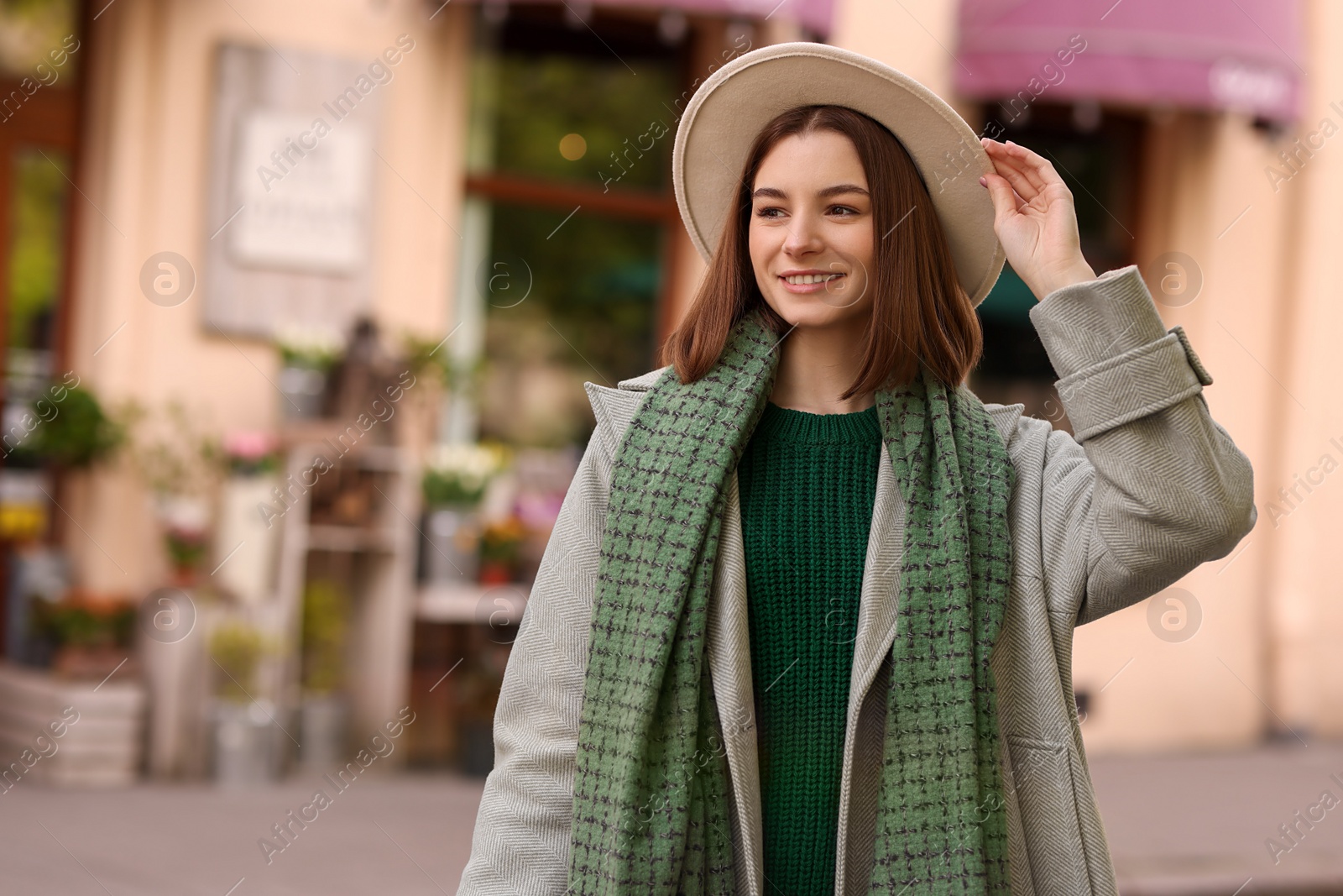 Photo of Beautiful woman in warm scarf and hat outdoors