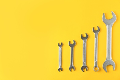 Photo of New wrenches on color background, top view with space for text. Plumber tools