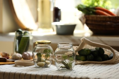 Photo of Empty glass jars and ingredients prepared for canning on table