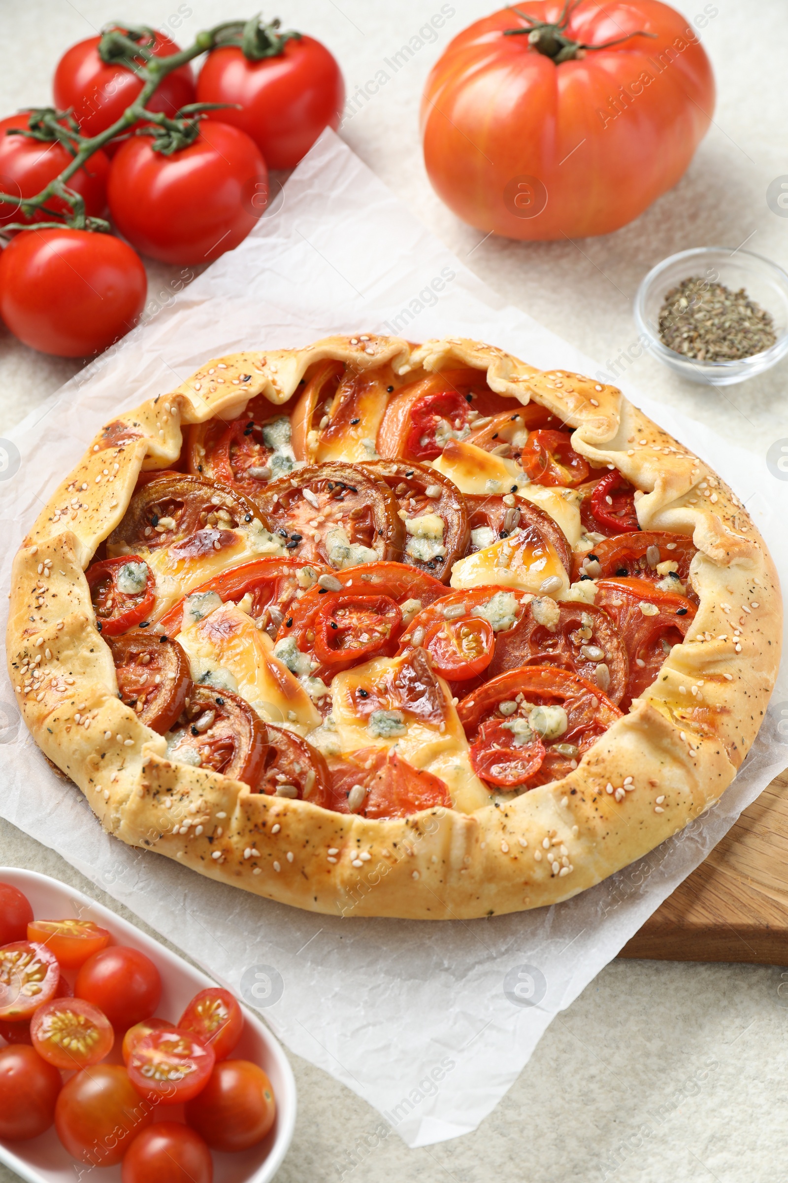 Photo of Tasty galette with tomato and cheese (Caprese galette) on light textured table