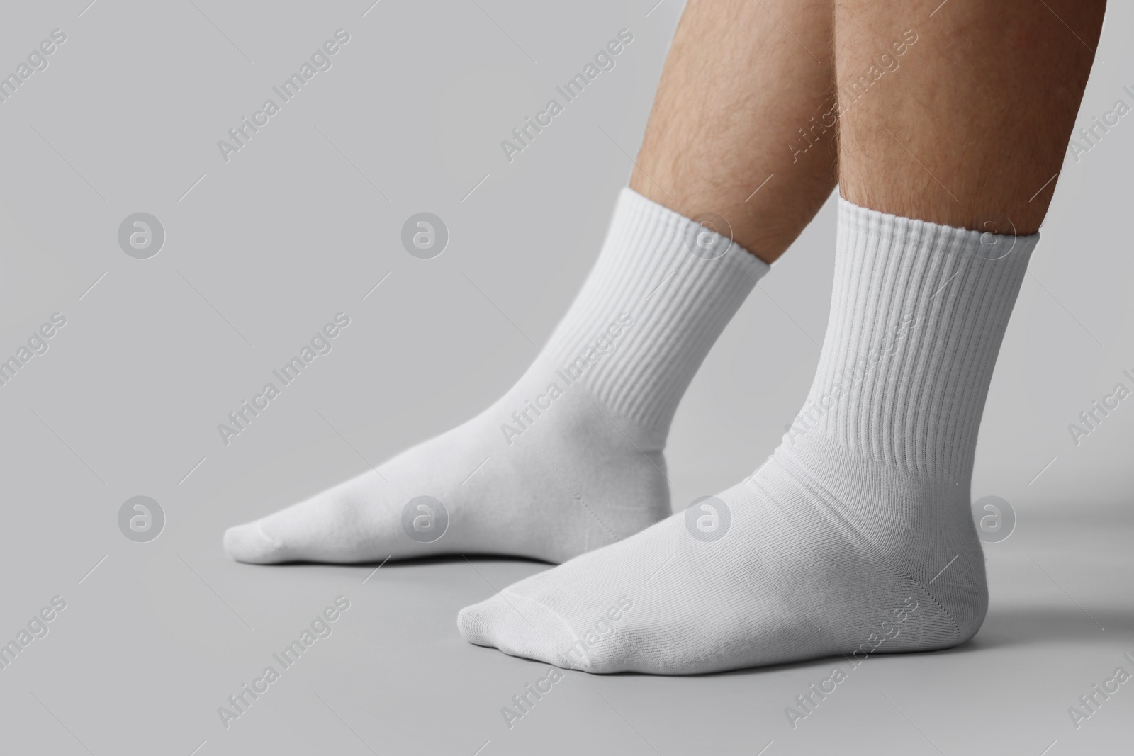 Photo of Man in stylish white socks on light grey background, closeup