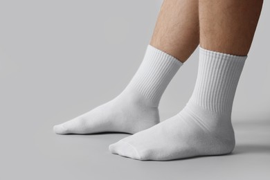 Photo of Man in stylish white socks on light grey background, closeup