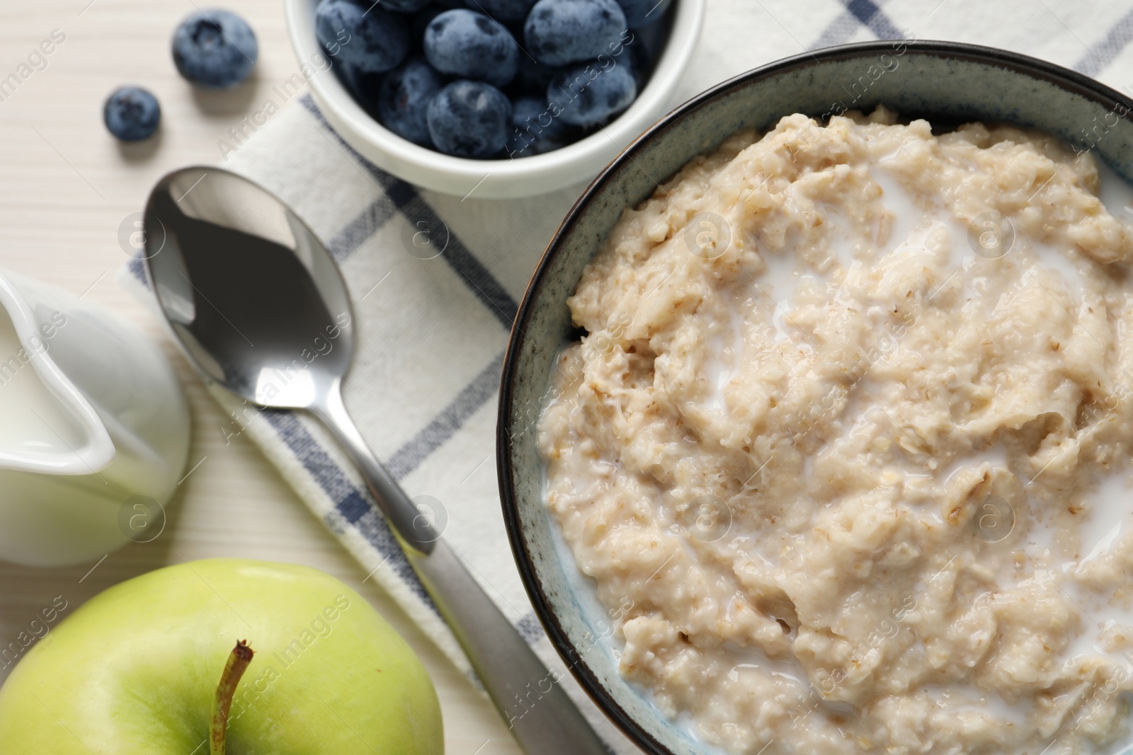 Photo of Tasty oatmeal porridge served on light table, flat lay