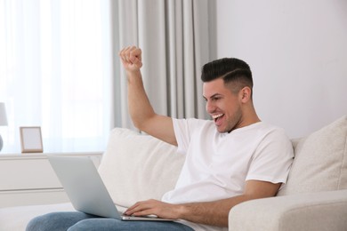 Emotional man participating in online auction using laptop at home