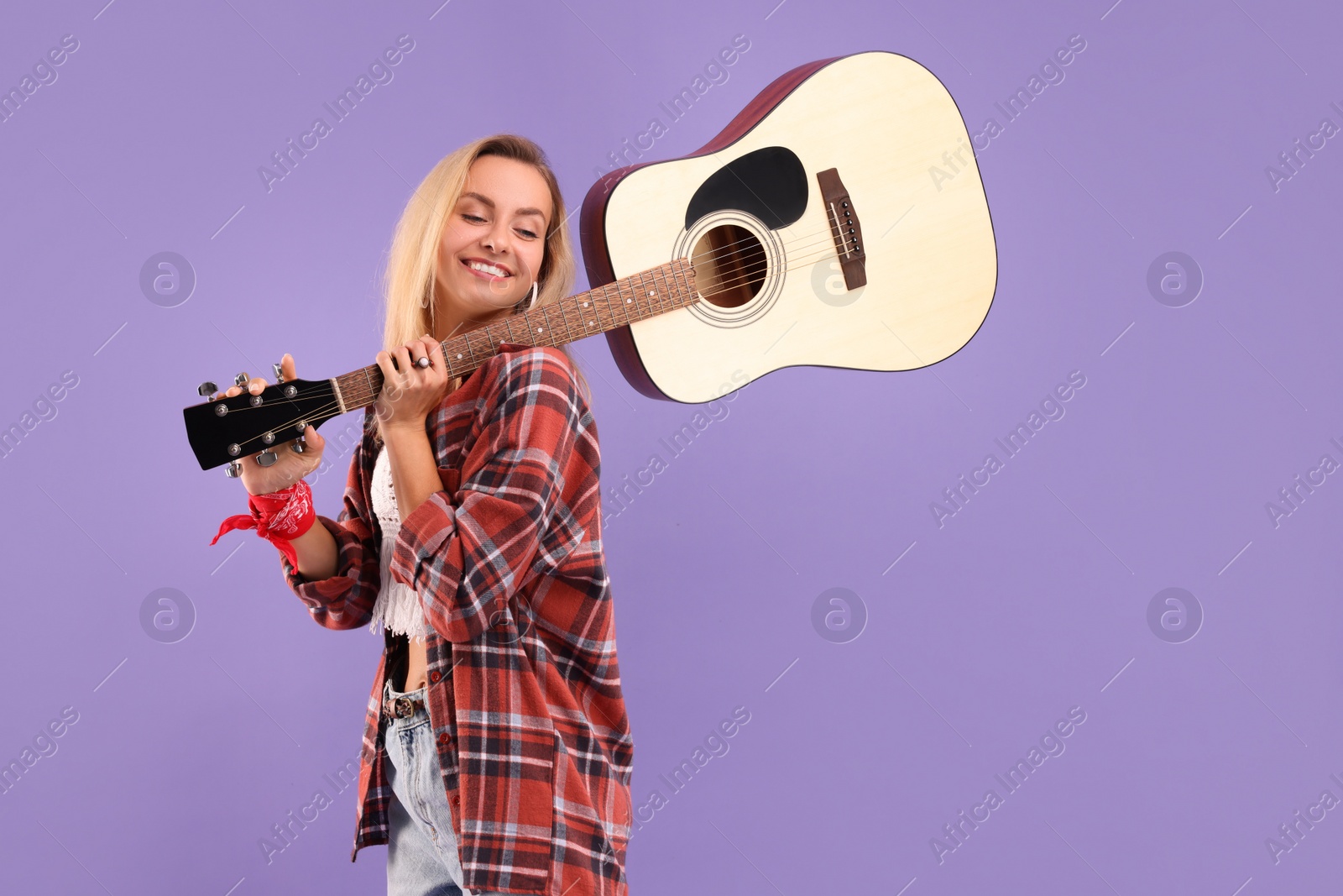 Photo of Happy hippie woman with guitar on purple background. Space for text