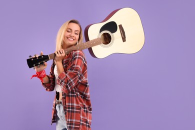 Happy hippie woman with guitar on purple background. Space for text