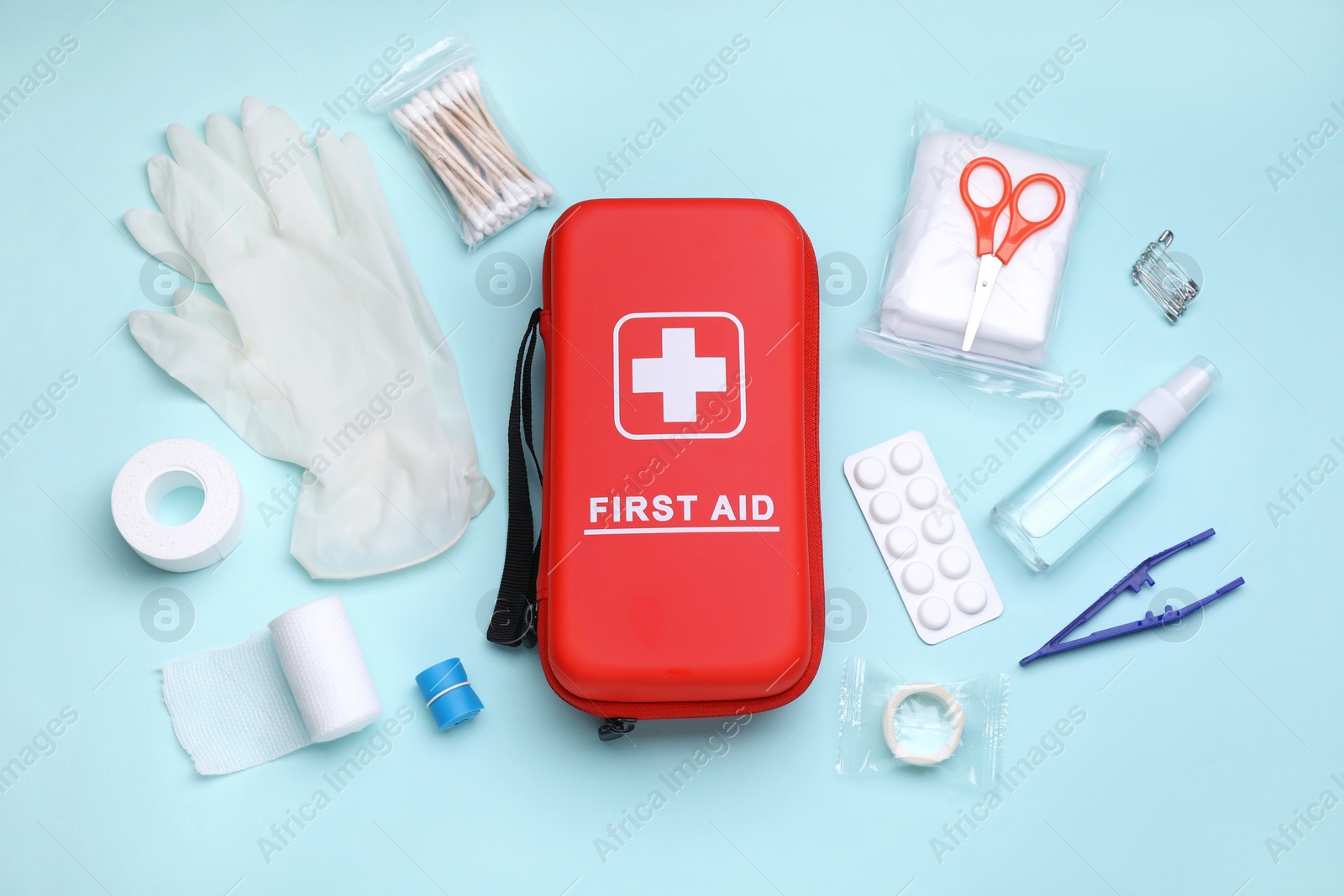 Photo of Flat lay composition with first aid kit on light blue background