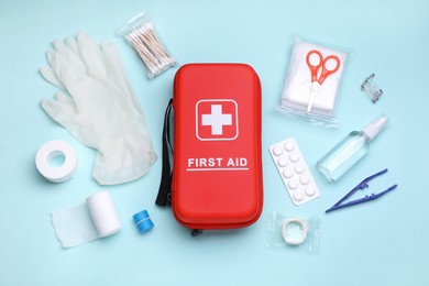 Photo of Flat lay composition with first aid kit on light blue background