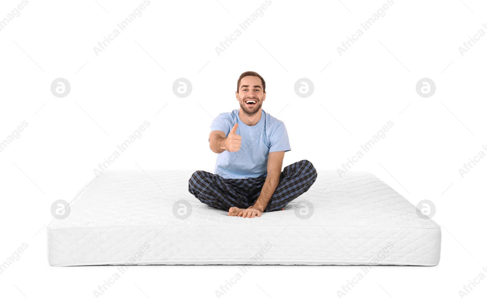 Photo of Young man sitting on mattress against white background