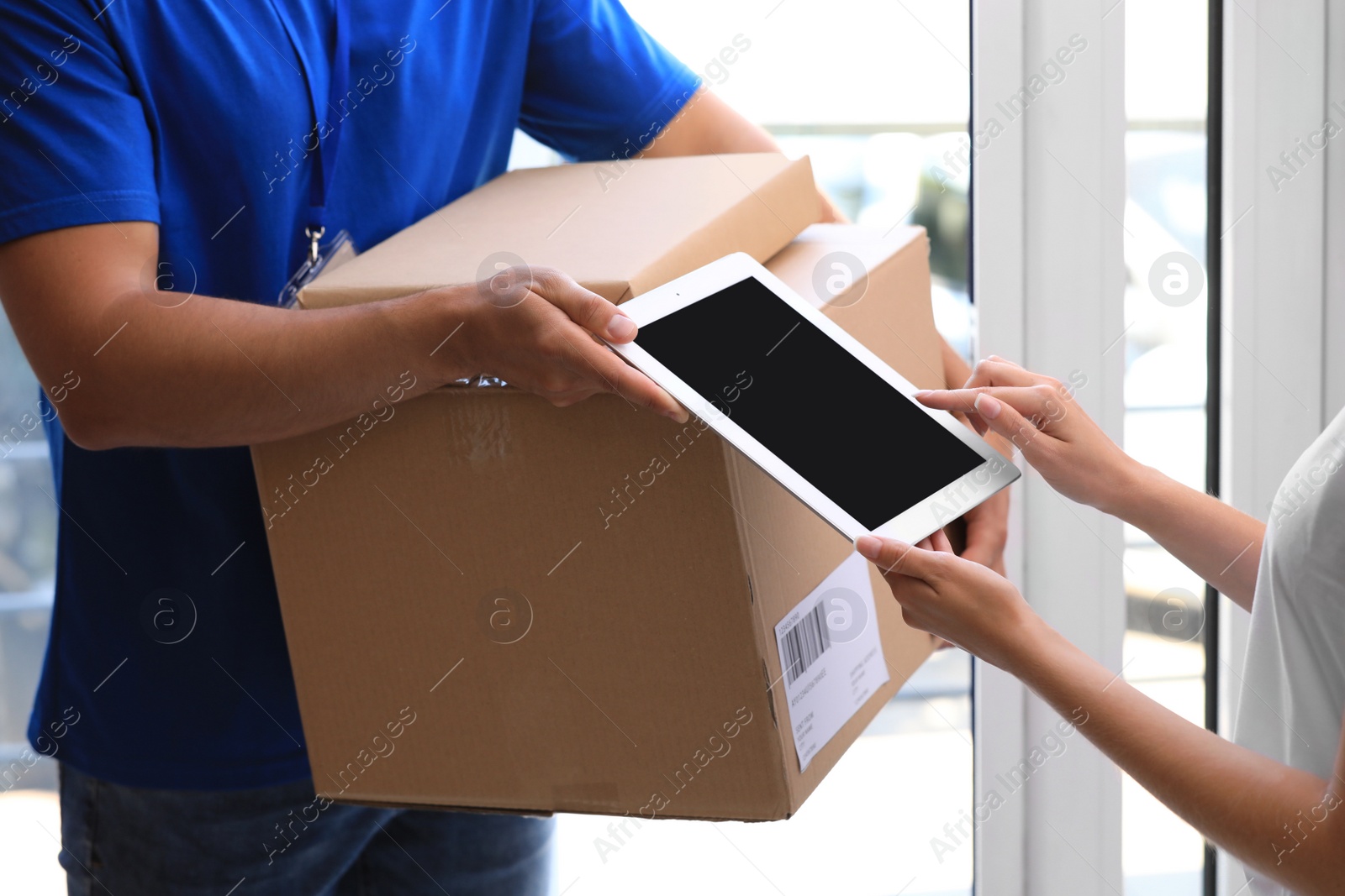 Photo of Woman using app to confirm delivery of parcels from courier on doorstep, closeup