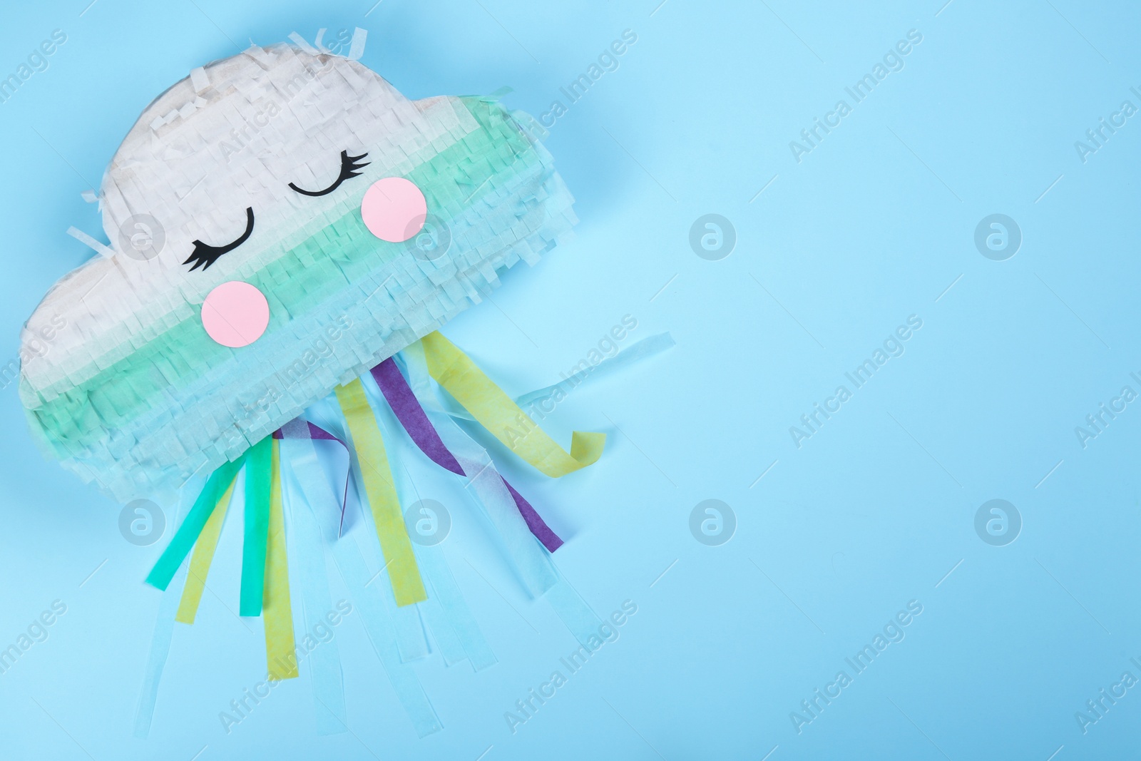 Photo of Bright cloud pinata on light blue background, top view. Space for text