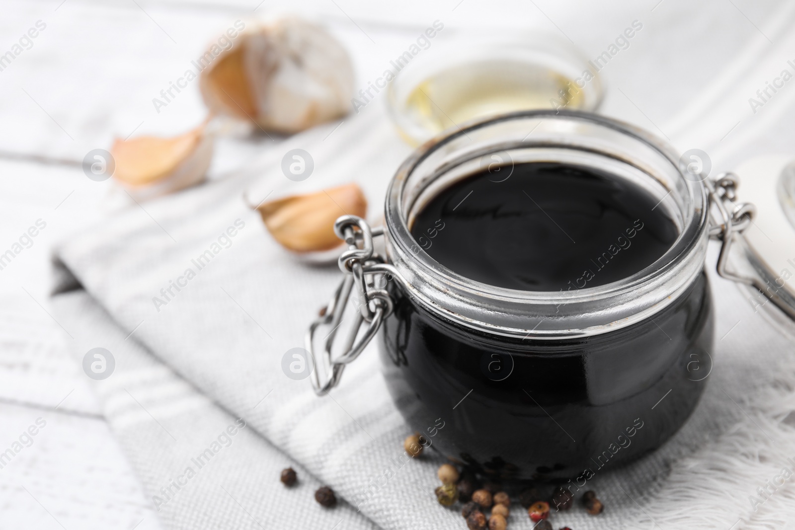 Photo of Organic balsamic vinegar and cooking ingredients on white table, closeup. Space for text