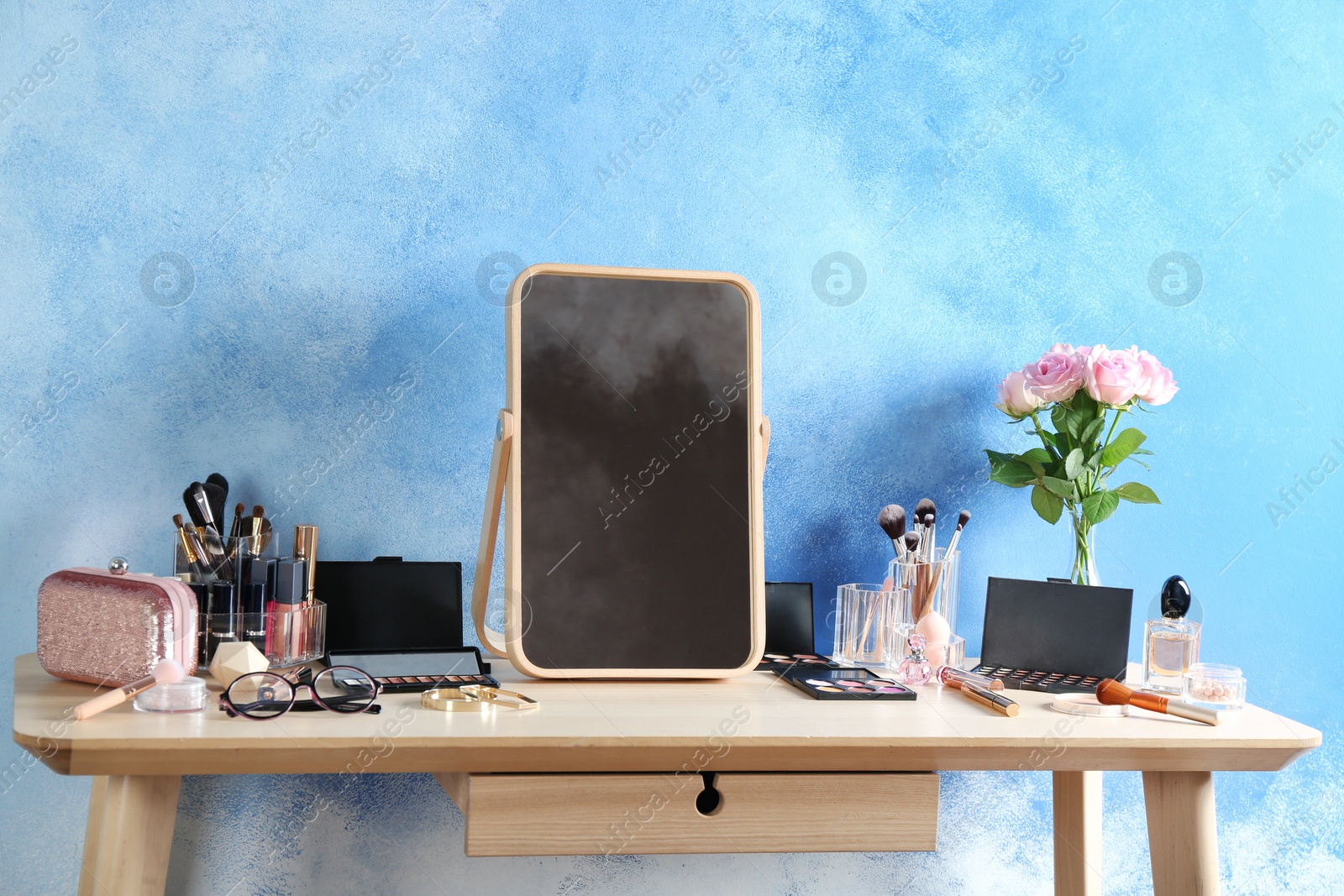 Photo of Dressing table with beauty accessories near color wall in room