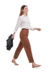 Beautiful businesswoman with briefcase walking on white background